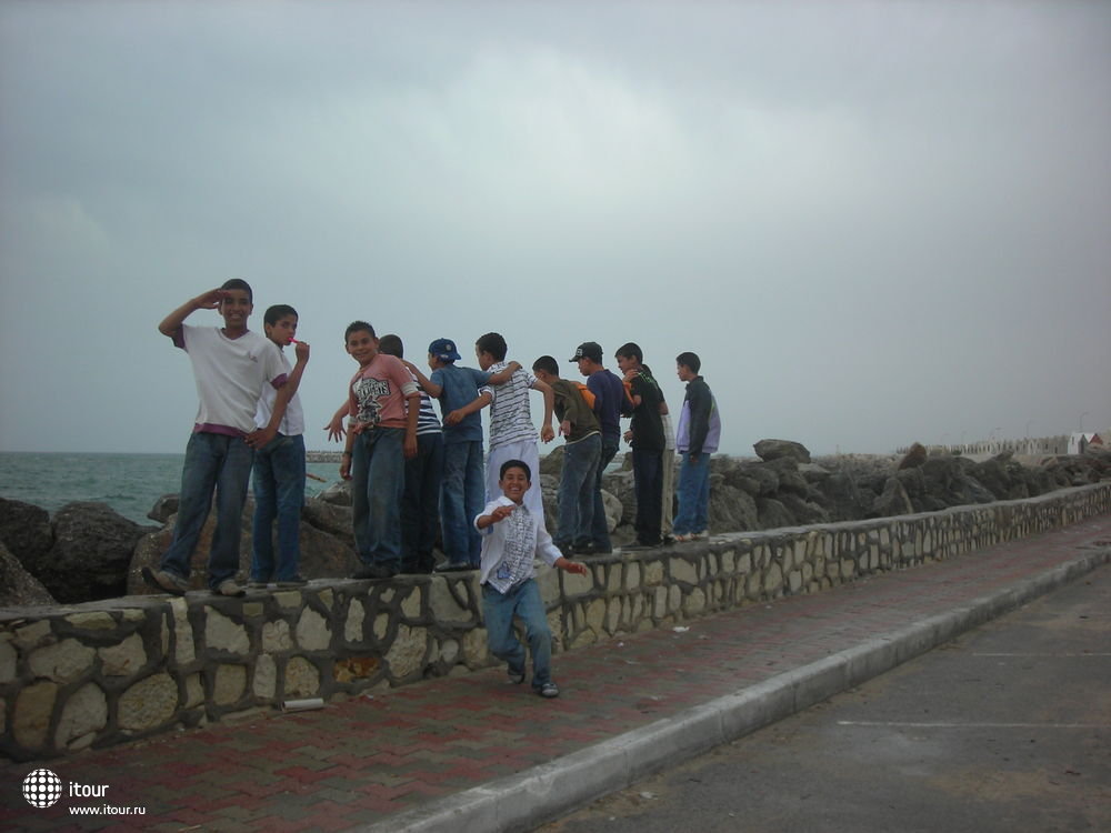 Местные мальчики ловят волны во время шторма, Махдия