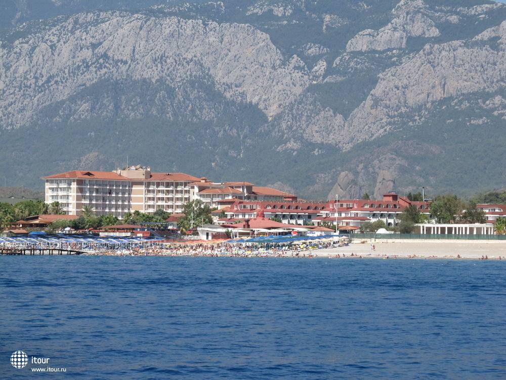 Вид на пляж с моря. Зонты отеля кирпичного или персикового цвета