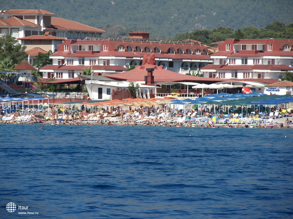 Вид на пляж с моря. Зонты отеля кирпичного или персикового цвета