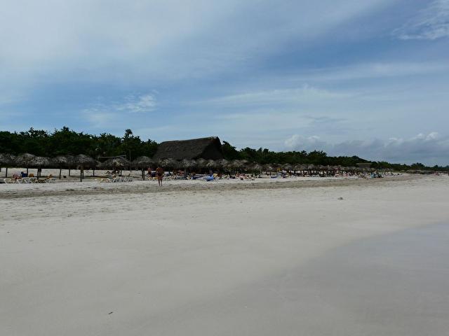 Часть пляжа с пляжным баром посередине.