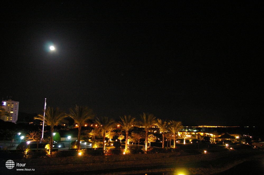 Вид на территорию отеля и море ночью